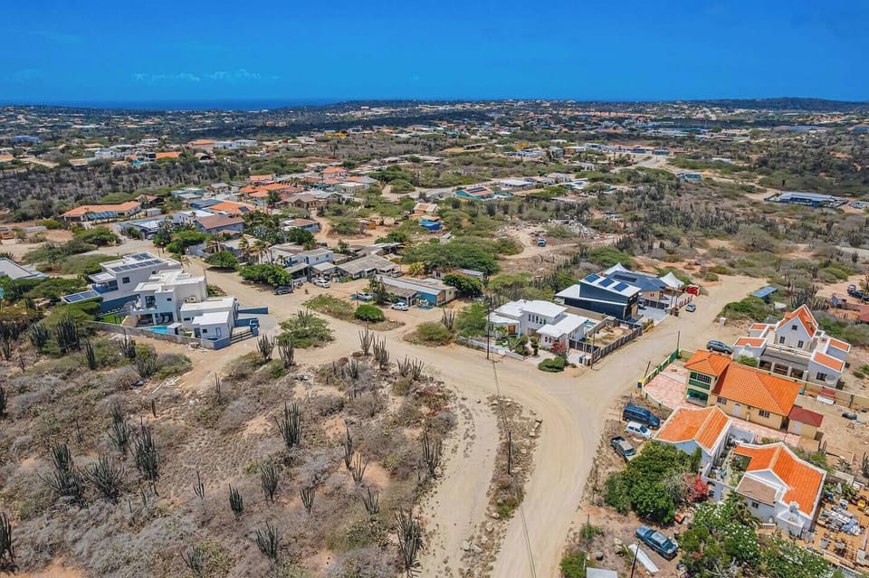 This aerial perspective shows the villa’s quiet neighborhood setting and easy access to explore northern Aruba.