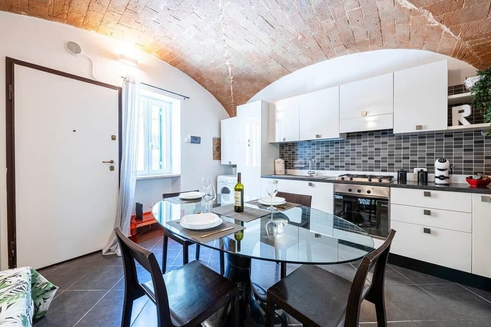 La cucina e' composto da forno elettrico con vassoio interno, macchina da caffe con cialde di cortesia e piano cottura a Gas con 4 fuochi. Sul fianco sinistro si trova una comoda lavatrice con capsule di detersivo in offerta.