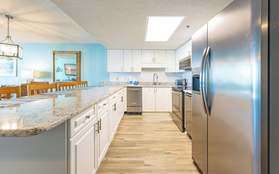 Granite countertops gleam as you prepare fresh meals in the kitchen with stainless steel appliances and wood-style floors