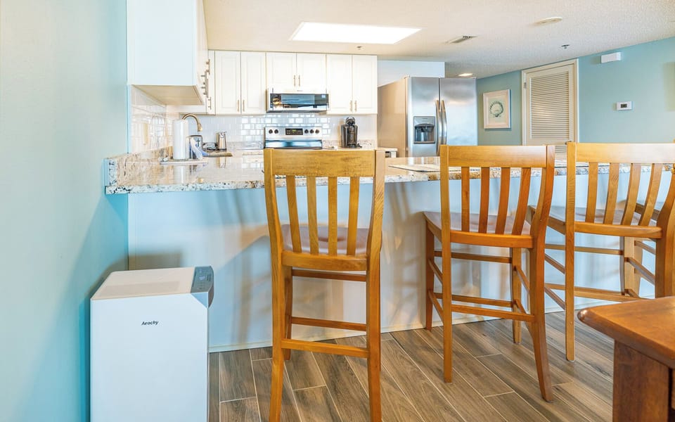 Warm light from the overhead fixture invites you to gather around the breakfast bar in the kitchen