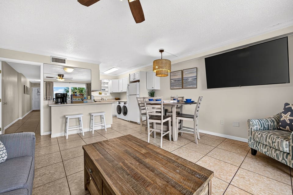 Bright open living space with breakfast bar, dining area, and in-unit laundry