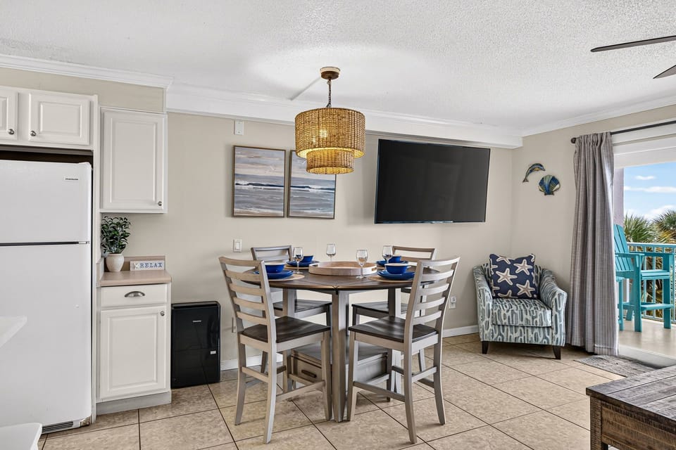 Bright coastal dining nook with TV and balcony access