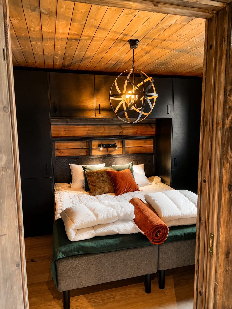 Warm and inviting double bedroom with soft lighting and mountain lodge characte
