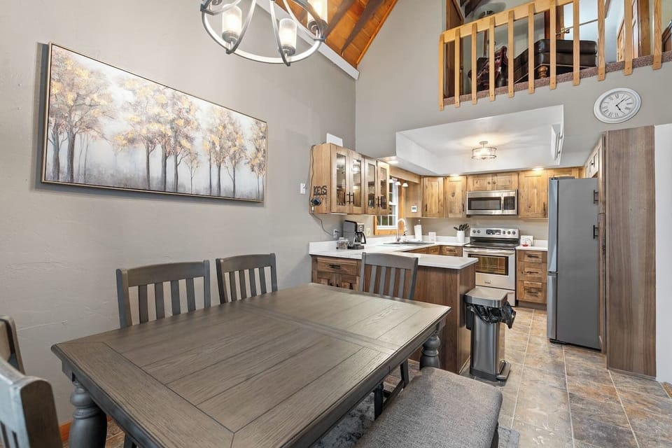 The dining and kitchen areas offer a warm and inviting space, featuring a comfortable dining setup and a well-equipped kitchen perfect for preparing meals and gathering together.