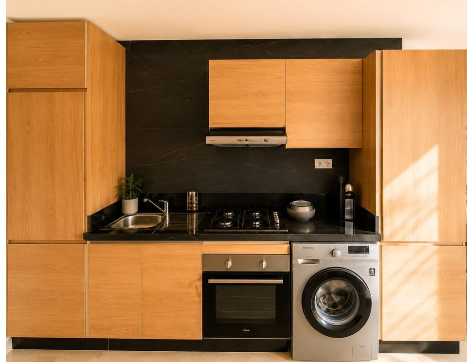 Modern wood kitchen with washer, oven, and sleek black finishes