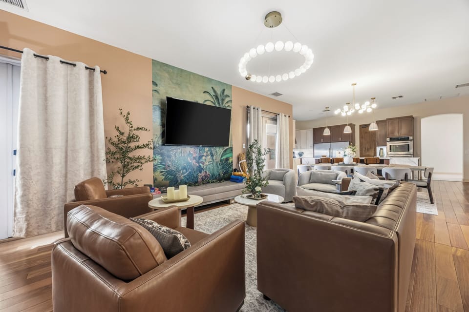 Stylish open living with tropical mural, luxe seating & chef’s kitchen