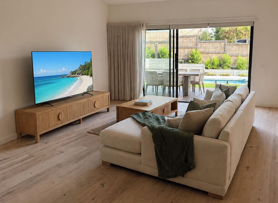 Bright modern lounge with Smart TV, pool views, and seamless indoor-outdoor living