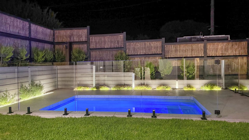 Private illuminated pool with modern design and a serene nighttime vibe