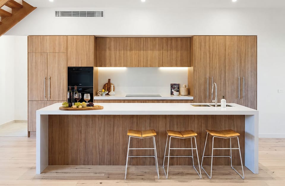 Sleek modern kitchen with waterfall island and warm wood finishes