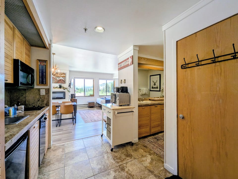 Step into your mountain retreat where warm wood tones blend with modern amenities. The open-concept kitchen flows into a sun-filled living space, perfect for relaxing after a day of adventure.