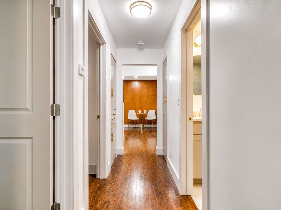 Bright hallway with warm wood floors leading to a cozy dining nook