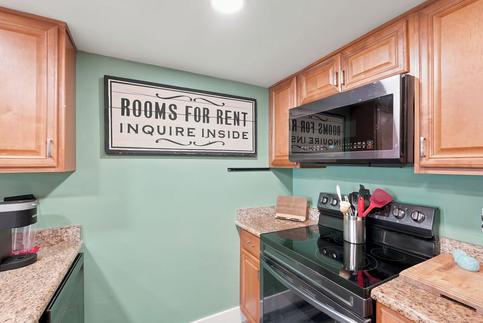Your fully equipped kitchen features warm wood cabinetry, granite counters, and modern appliances—ready for you to whip up anything from coffee to a home-cooked meal during your stay.