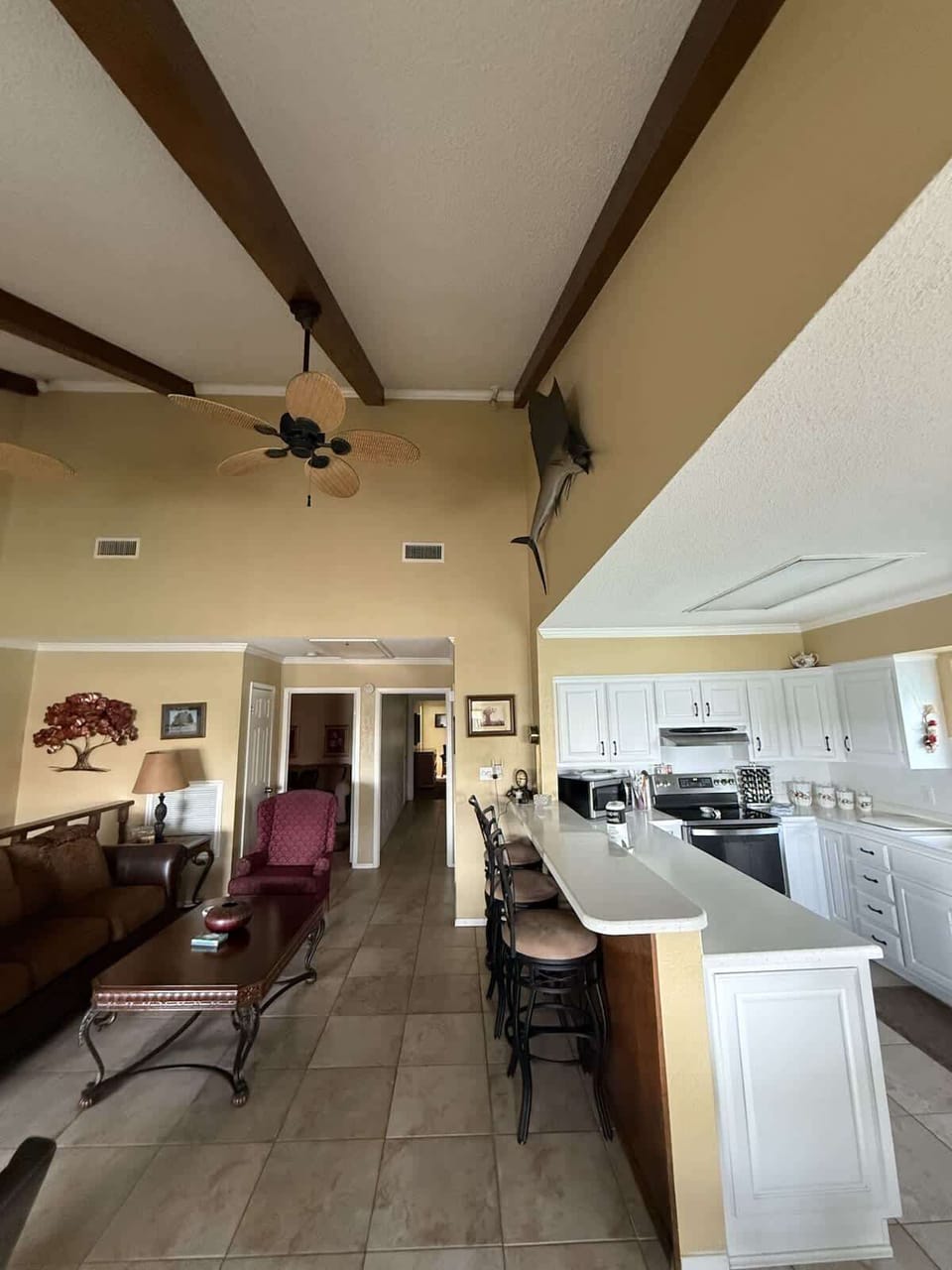 Open plan kitchen and living area with comfortable seating and TV lounge, perfect for cooking, dining, and relaxing together as a group