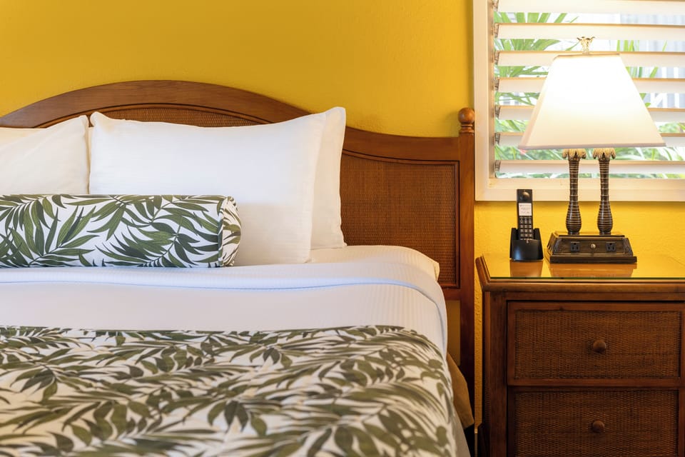 Drift off beside warm lighting and soft, tropical bedding.