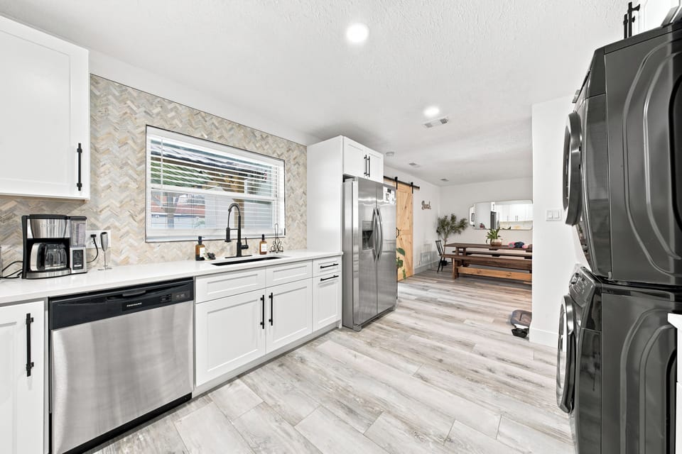 Bright modern kitchen with stainless appliances and in-home laundry