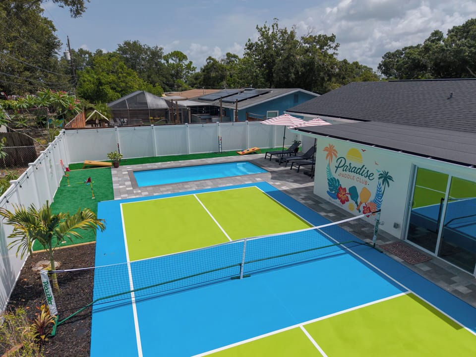 Private backyard with pickleball court, pool, and resort-style lounge area