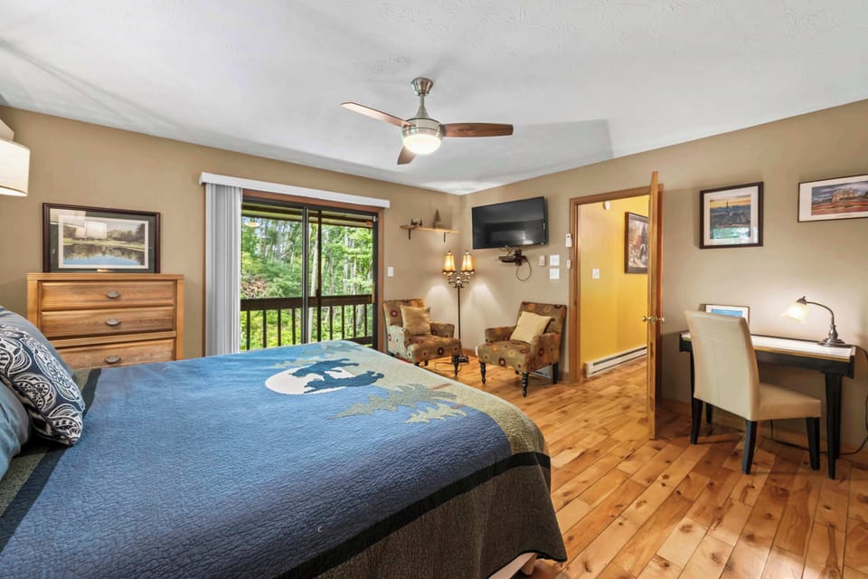 King bedroom designed for comfort with a workspace and deck access