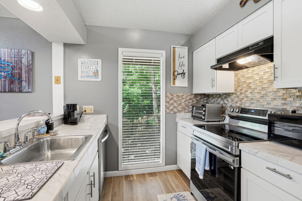Bright modern kitchen with stainless appliances and natural light