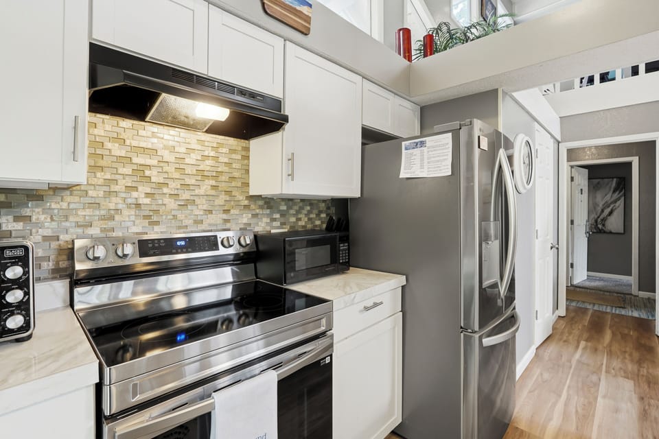 Bright modern kitchen with stainless appliances and soaring ceilings