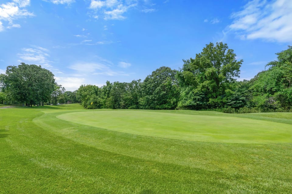 Scenic golf course views with lush greens and a peaceful tree-lined setting