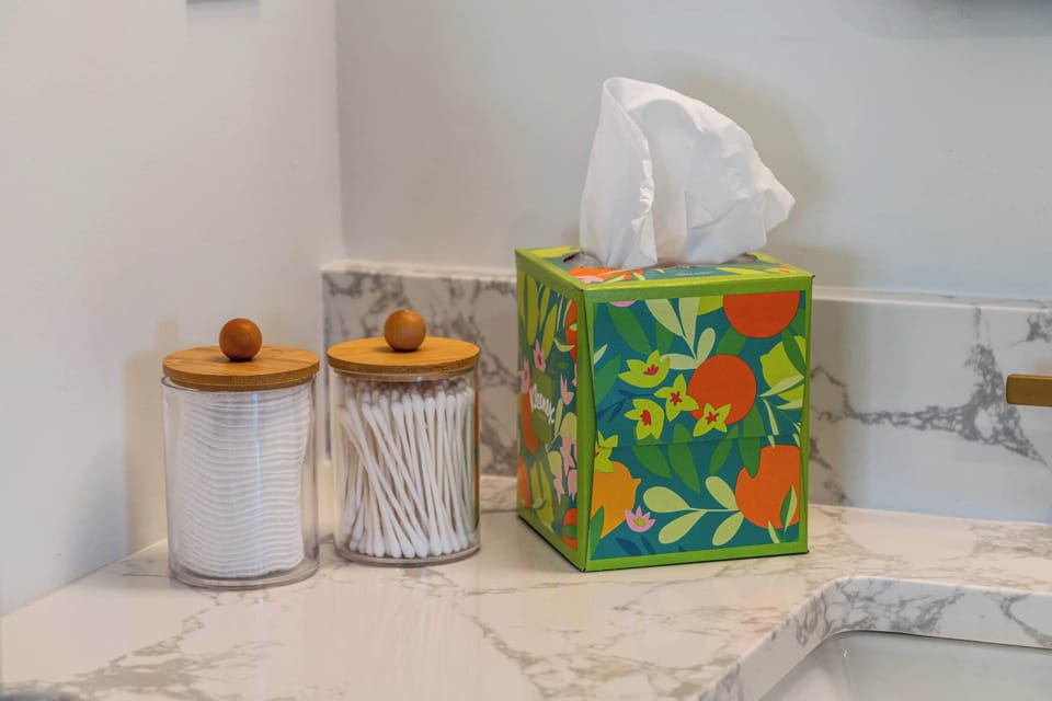 Marble bathroom counter with cotton buds and everyday toiletries.