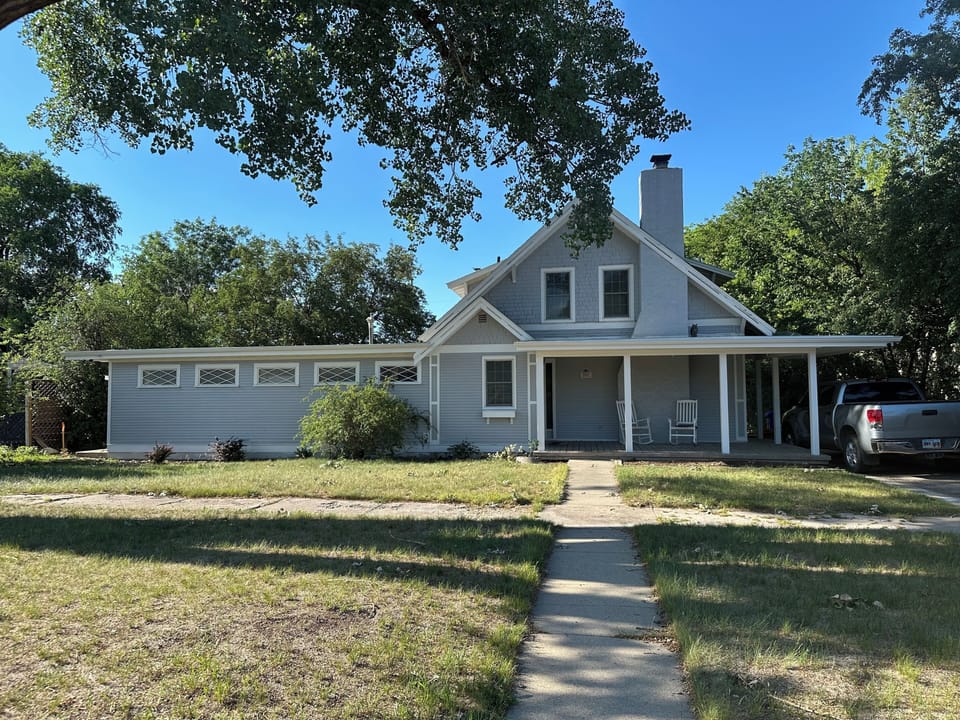 Charming farmhouse-style home with shaded porch and convenient parking