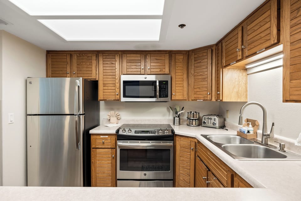 Fully equipped kitchen with stainless steel appliances, ample cabinetry, generous counter space, and all the essentials for preparing meals during your stay.