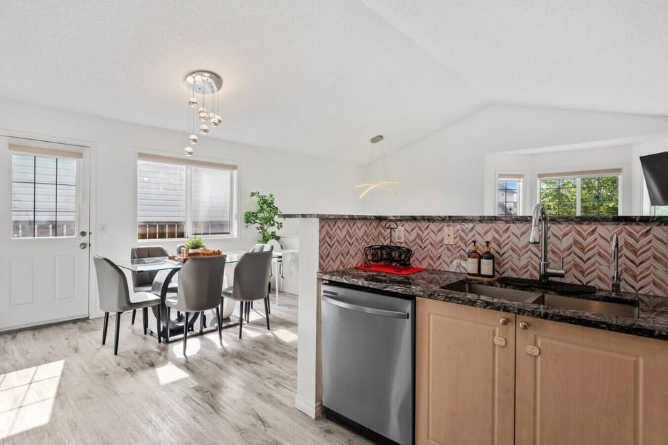 Well-equipped kitchen with black granite countertops and decorative herringbone backsplash
