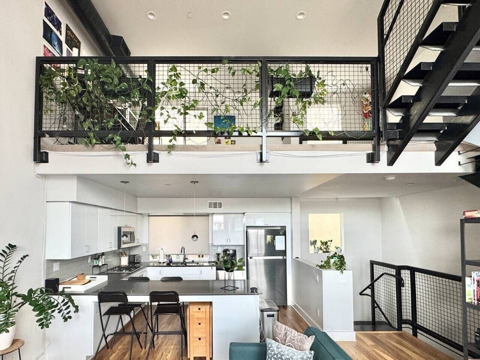 An open loft layout with greenery overhead, giving the whole space room to breathe.