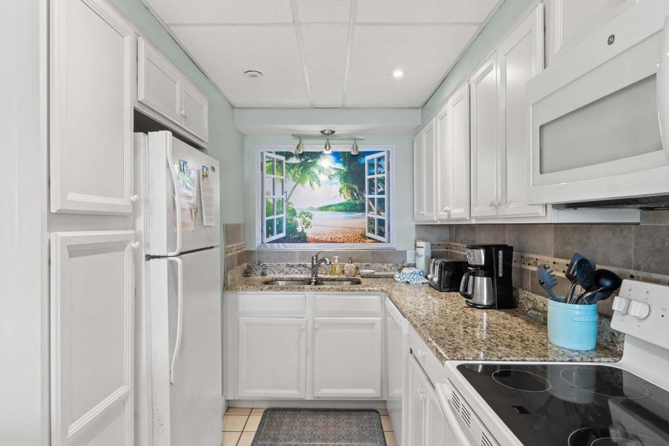 Bright finishes make the space feel welcoming including a painting of a beach scene.