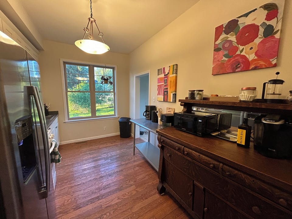 Kitchen with tea, coffee, French press, conventional coffee maker, blender, microwave and more.