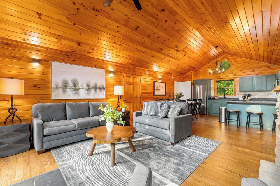 Cozy open-concept cabin living room with vaulted wood ceilings
