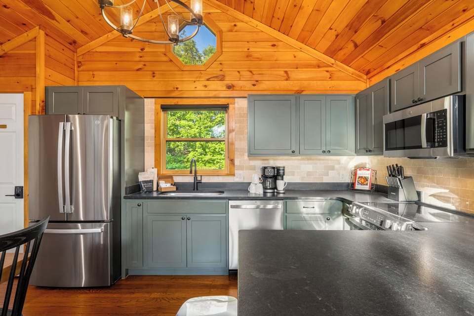 Rustic-modern kitchen with vaulted wood ceilings and stainless appliances