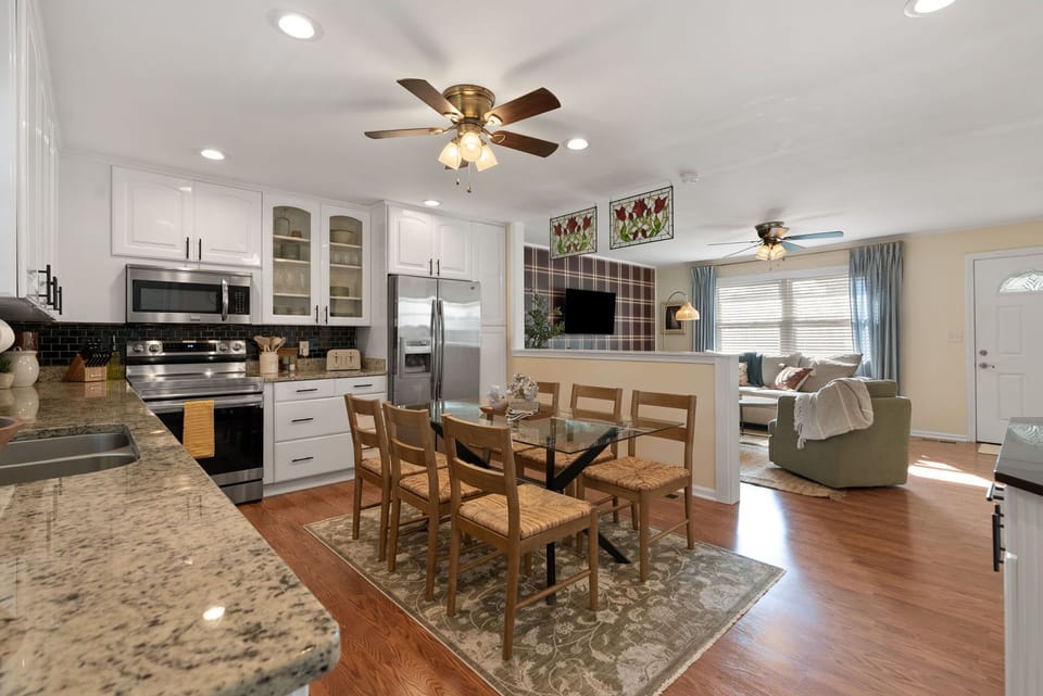 Our kitchen and dining table (seats 6). Our kitchen is fully stocked with everything you need to cook a meal at home, plus all of the usual appliances: full sized fridge, stove, oven, microwave, dishwasher, and toaster.