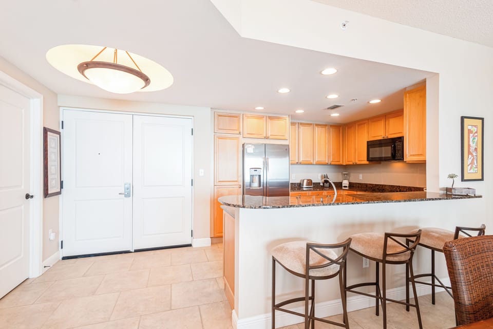 Gather around the breakfast bar for morning coffee or quick meals. Your fully-equipped kitchen with granite counters, stainless appliances, and open layout invites effortless entertaining.