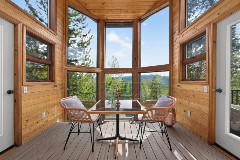 Sip your morning coffee at this cozy dining nook, where panoramic mountain views and fresh pine-scented air create your perfect retreat.
