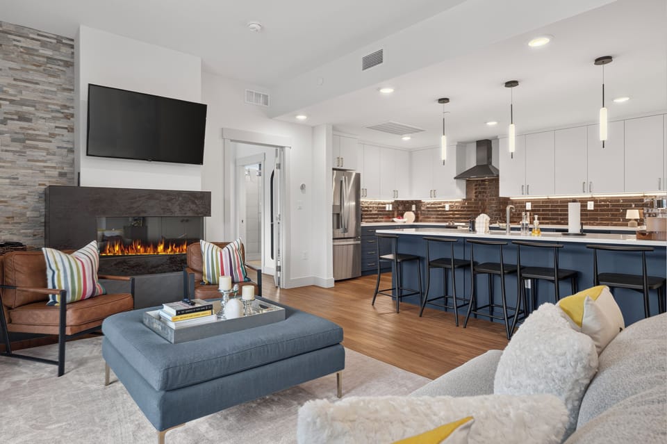 Sink into plush seating by the glowing fireplace, then gather around the spacious island for meals and conversation. Your modern retreat blends cozy comfort with sleek style.