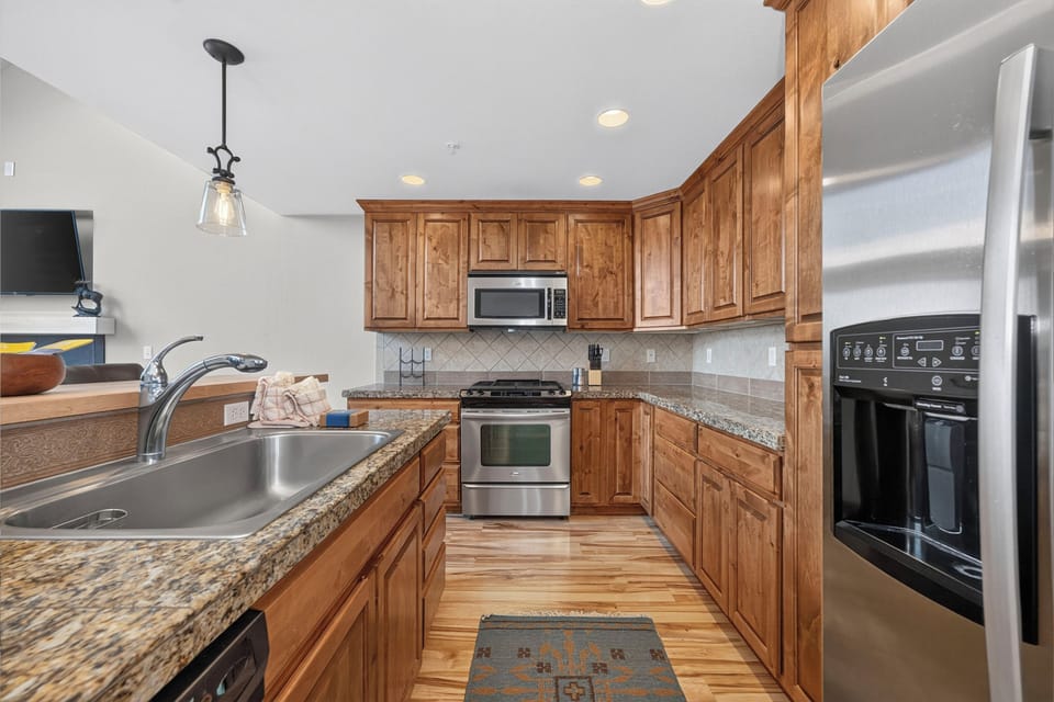 Your fully equipped kitchen features warm wood cabinetry, granite counters, and stainless appliances—everything you need to prepare meals in style and comfort.