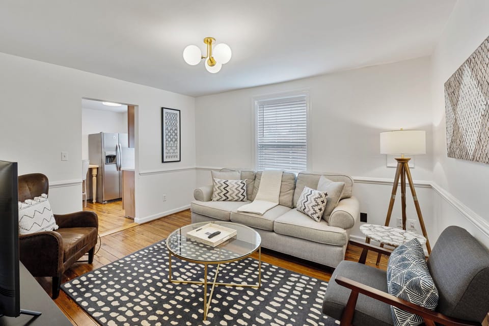 The living room features comfy seating and large smart TV