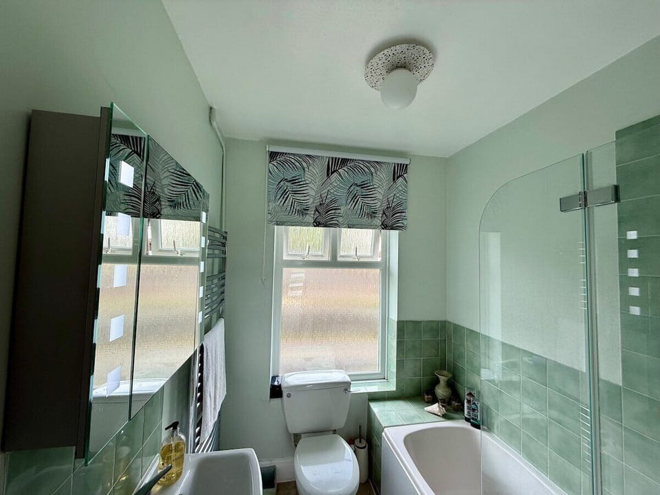 Bathroom with bath and shower over bath on first floor