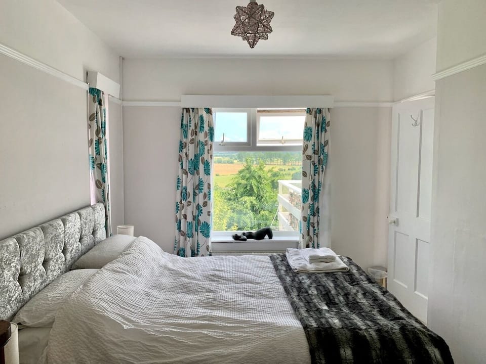 Kingsize bed with Emma mattress looking out over the Somerset levels and the Tor, light and airy with windows on 3 sides