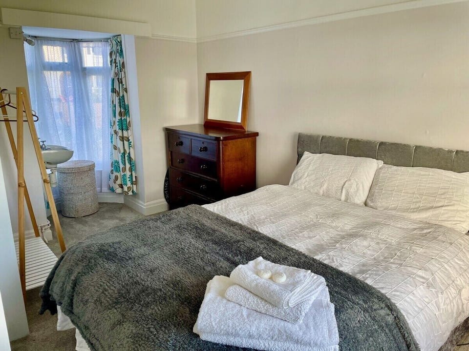 Triple aspect room with small bay window, vanity sink and black out curtains