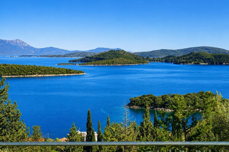 Panoramic view of lush green islands scattered across a calm blue sea.