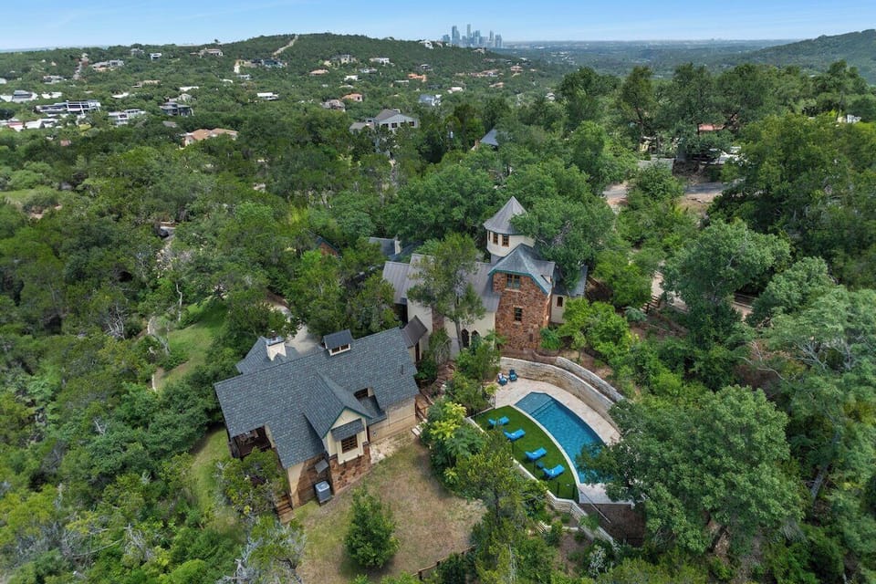 Daytime aerial capturing the compound with downtown Austin beyond