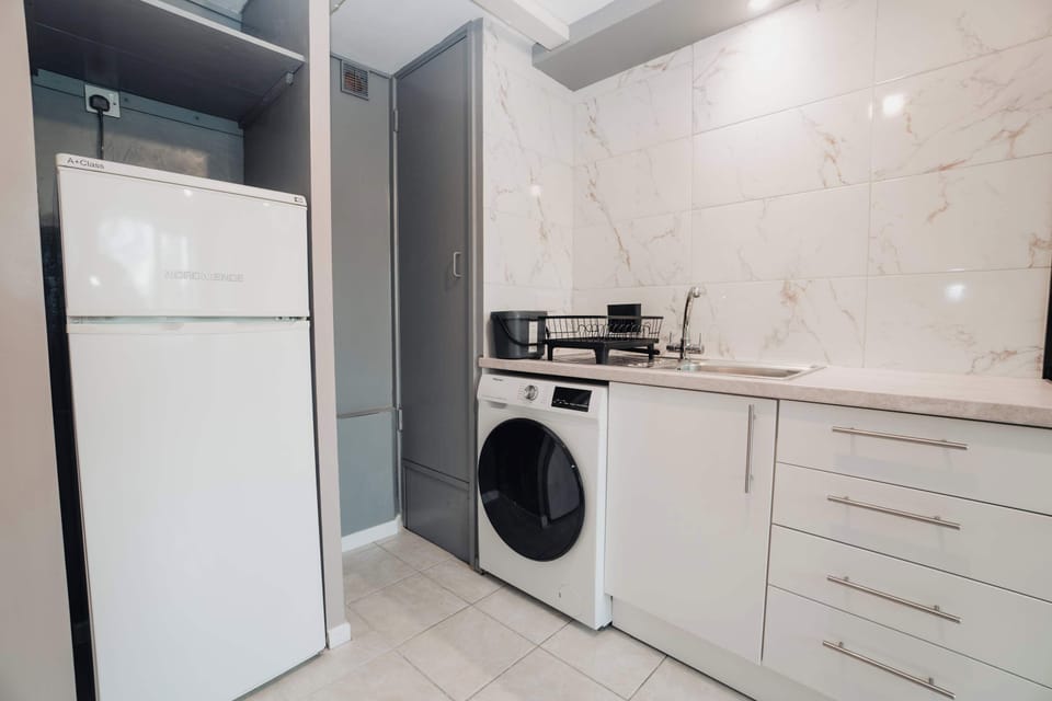 A tall fridge freezer with room for a proper weekly shop, and a washing machine with a free dryer beside it. Four weeks here and you never need a launderette or a hotel laundry bill.