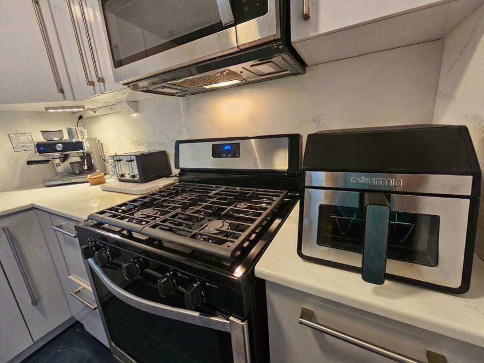 Modern kitchen with gas range, espresso machine, and handy air fryer