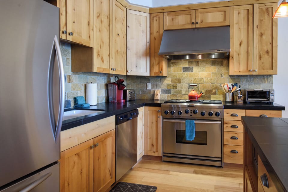 Rustic kitchen with stainless appliances and a chef-style gas range