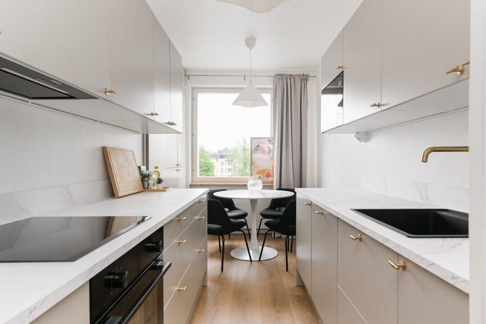 Kitchen wide view with induction hob, oven and dining nook - Sammonkatu 5 B 22