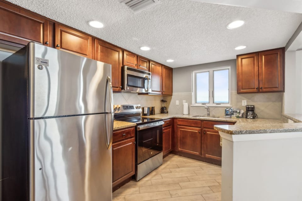 Spacious Kitchen with Oceanfront View, Granite Countertops, and Stainless-Steel Appliances