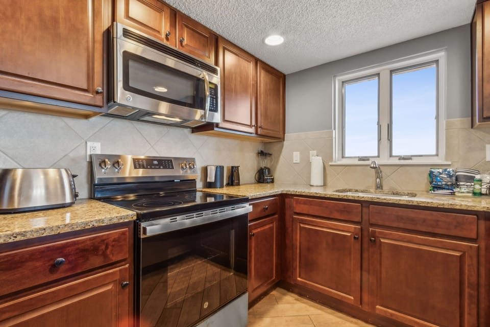 Spacious Kitchen with Oceanfront View, Granite Countertops, and Stainless-Steel Appliances